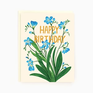 Peut inclure: Une carte de vœux avec un motif floral composé de fleurs bleues et de feuilles vertes. La carte porte le texte "Happy Birthday" en lettres dorées.