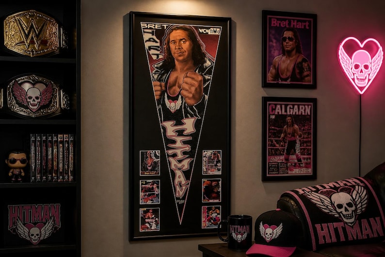 May include: A room featuring wrestling memorabilia. A large framed poster of Bret Hart is the focal point, along with framed posters, championship belts, and a neon heart-shaped sign. A shelf displays belts, DVDs, and a figurine.