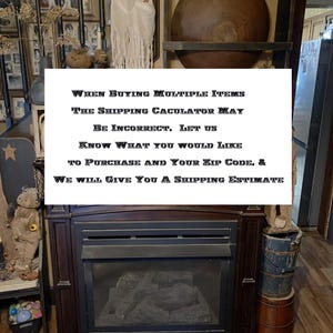 May include: A sign with the text "WHEN BUYING MULTIPLE ITEMS THE SHIPPING CALCULATOR MAY BE INCORRECT, LET US KNOW WHAT YOU WOULD LIKE TO PURCHASE AND YOUR ZIP CODE, & WE WILL GIVE YOU A SHIPPING ESTIMATE". The sign is in front of a fireplace with a ghost figurine and other decorative items.