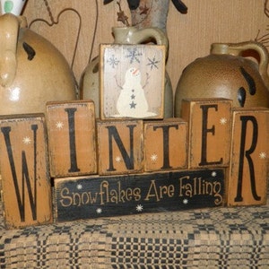 Winter snowflakes are falling primitive block sign