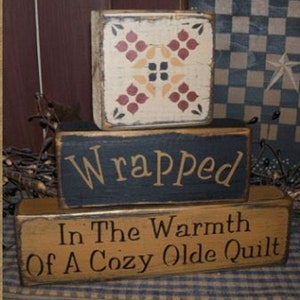 Wrapped in the warmth of a cozy olde quilt blocks Primitive Sign