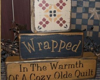 Wrapped in the warmth of a cozy olde quilt blocks Primitive Sign