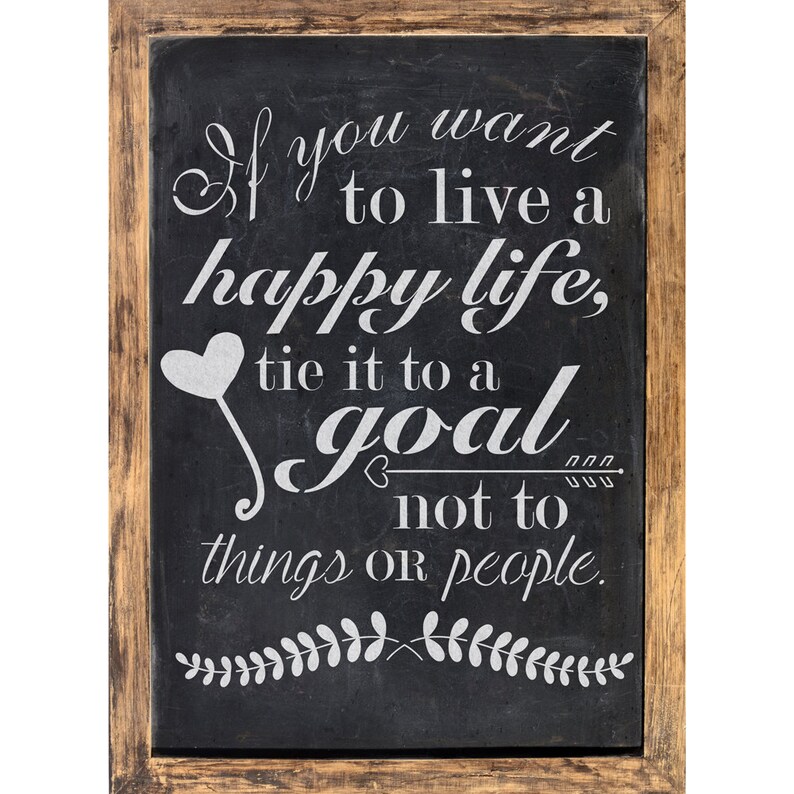 May include: A black chalkboard with a white wooden frame, featuring a motivational quote: "If you want to live a happy life, tie it to a goal not to things or people."