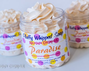 May include: Three clear jars of "Fluffy Whipped Soap Paradise" with a whipped cream-like texture. Each jar has a label with colorful polka dots and the brand name "Xplosive CosmetiX". The soap is a light beige color.