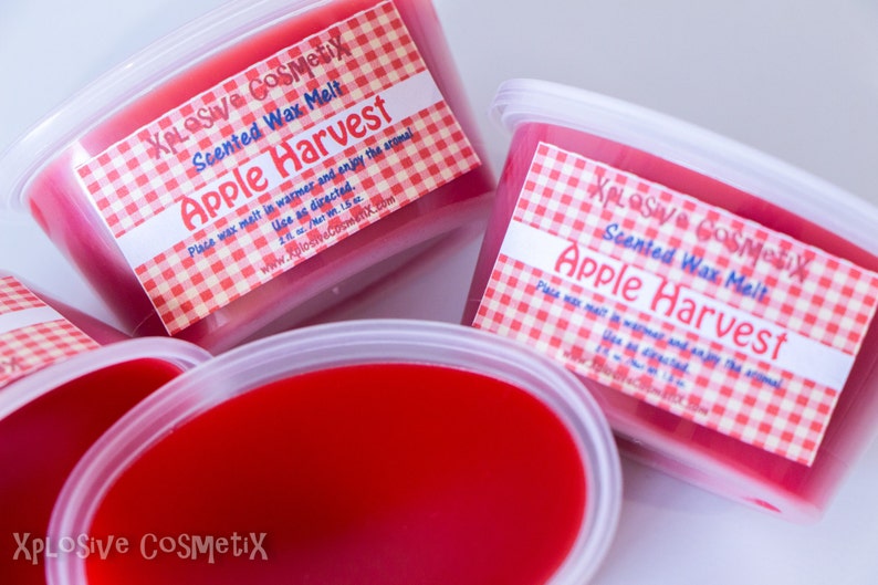 May include: Three containers of red scented wax melt with a white label that says "XPLOSIVE COSMEtix Scented Wax Melt Apple Harvest". The label has a red and white checkered pattern.