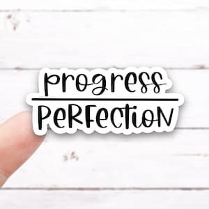 May include: White sticker with black text that reads "progress over perfection".
