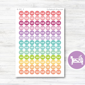 May include: A sheet of 100 colorful round stickers featuring a white silhouette of a rowing machine. The stickers are arranged in a rainbow gradient from pink to orange, yellow, green, blue, purple, and pink. The text "B-242_3" and "itsAwhoot.etsy.com" are printed at the top of the sheet.