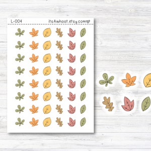 May include: A sheet of stickers featuring various autumn leaves in shades of green, yellow, orange, and red. The stickers are arranged in rows and columns on a white background. The text "itsAwhoot.etsy.com" and "L-004" are printed at the top of the sheet.