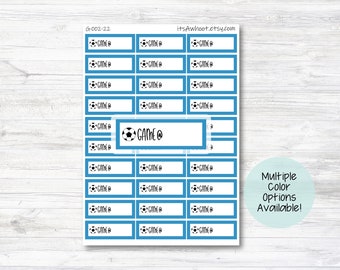 May include: A sheet of blue and white stickers with the text "GAME" on each sticker. The stickers are designed for a soccer or football theme and feature a soccer ball graphic. The text "Multiple Color Options Available!" is also included on the sheet.