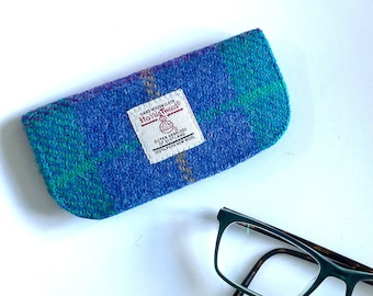 May include: A blue, green and purple tweed glasses case with a "Harris Tweed" label. The case is made of 100% pure new wool.