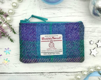 May include: A small blue, green, and purple zippered pouch made of Harris Tweed fabric. The pouch has a label that reads "HAND WOVEN CLOTH Harris Tweed® HARRIS TWEED OUTER HEBRIDES OF SCOTLAND 100% PURE NEW WOOL".