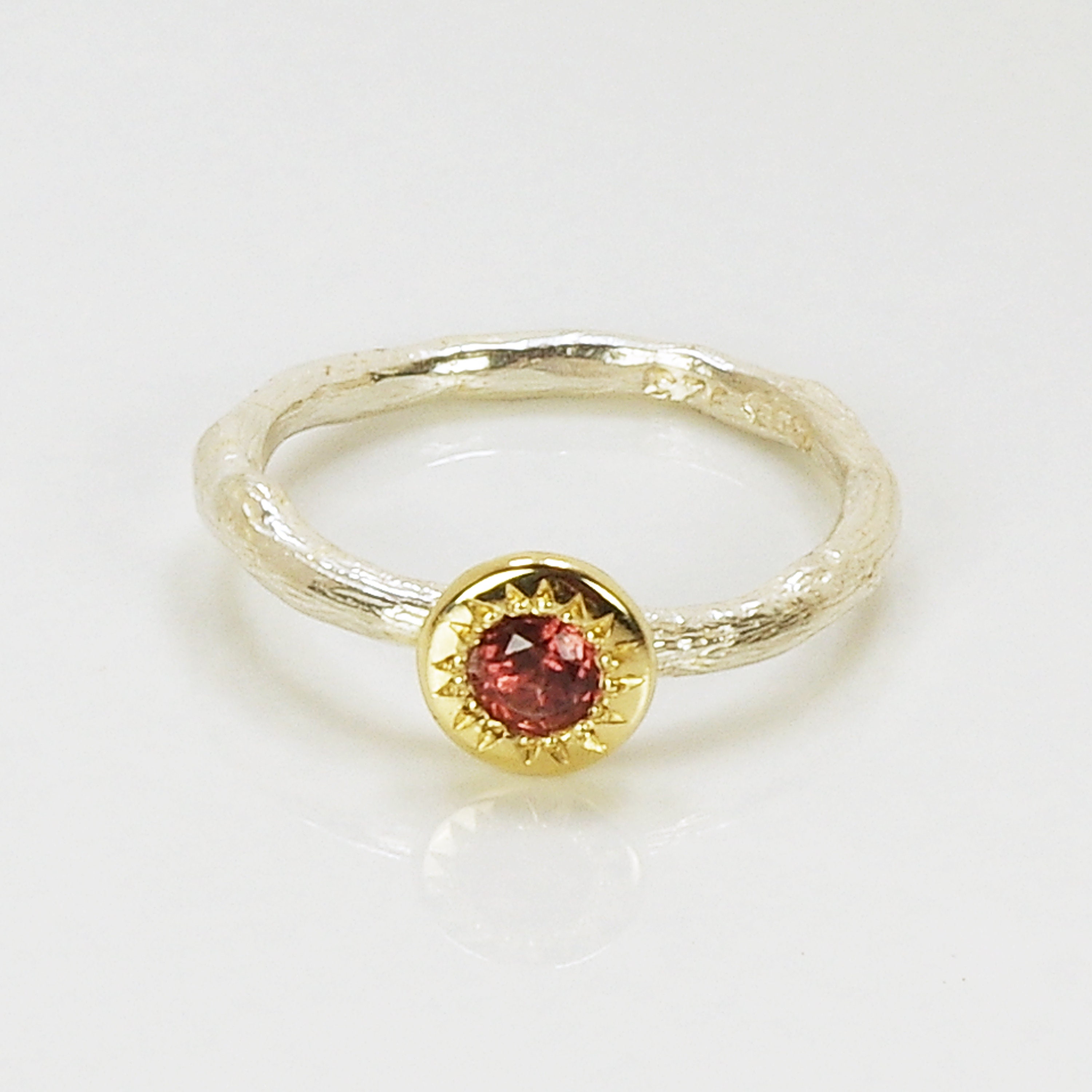 A Pink Garnet Set Into A Gold Sunflower on a Sterling Silver Ring
