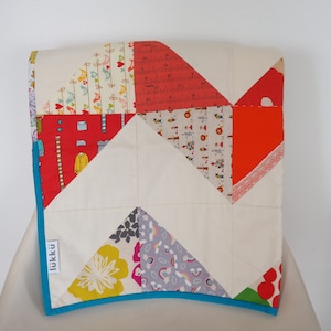 Hand quilted baby quilt, with patchwork back, in a handmade drawstring gift bag