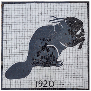 May include: A mosaic tile artwork featuring a black beaver holding a log, set against a white and gray tiled background. The year "1920" is displayed at the bottom. The artwork is framed with a black border.