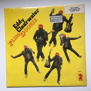 May include: A vintage vinyl record album cover for "Flim Doozie" by Eddy Clearwater. The album art features a yellow background with multiple images of Eddy Clearwater playing guitar. The text "Eddy Clearwater" and "Flim Doozie" are prominently displayed.