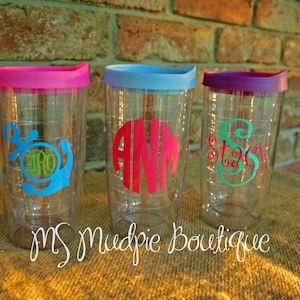 May include: Three clear plastic tumblers with colorful lids and personalized monograms. The tumblers have a straw hole and are perfect for everyday use.