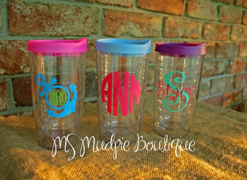May include: Three clear plastic tumblers with colorful lids and personalized monograms. The tumblers have a straw hole and are perfect for everyday use.