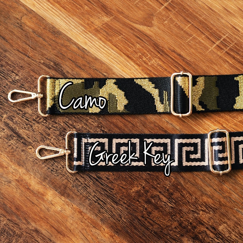May include: Two black and gold adjustable straps with gold clasps. The top strap has a camouflage pattern and the text "Camo". The bottom strap has a Greek key pattern and the text "Greek Key".
