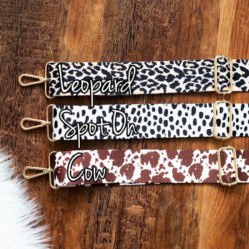 May include: Three different patterned fabric straps with gold metal hardware. The straps are labeled "Leopard", "Spot On", and "Cow".