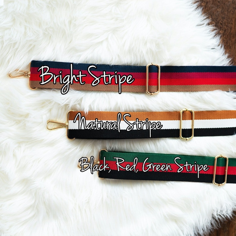 May include: Three different striped fabric straps with gold metal hardware. The straps are labeled "Bright Stripe", "Natural Stripe", and "Black, Red, Green Stripe".