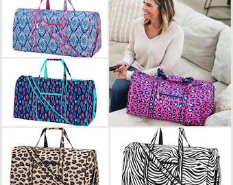 May include: Four different patterned duffel bags. The bags are all the same size and shape, but have different patterns. The patterns include a blue and pink paisley design, a blue and green geometric design, a pink and black leopard print, and a black and white zebra print.