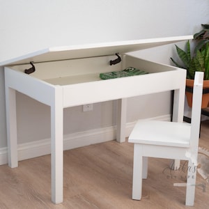 May include: White wooden desk with a lift-up top revealing storage space. The desk has a matching white chair.