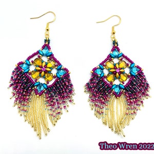 May include: A pair of handmade beaded earrings with a diamond-shaped design. The earrings feature a central flower design with yellow and pink beads, surrounded by turquoise and purple beads. Gold fringe hangs from the bottom, and the hooks are gold.