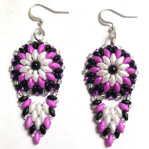 May include: A pair of dangle earrings with a purple, white, and black beaded flower design. The earrings have silver hooks.