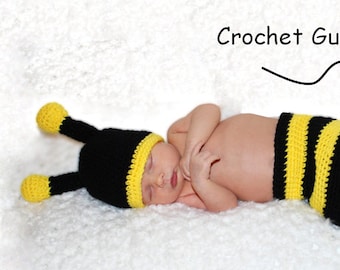 May include: A baby wearing a crocheted bee costume, including a hat and a body suit. The costume is black and yellow striped. The baby is lying on a white fluffy surface. Crochet Guru Pattern is written on the image.