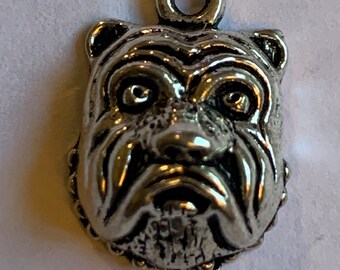 May include: Silver charm of a bulldog's face with a loop for attaching to a necklace or bracelet.