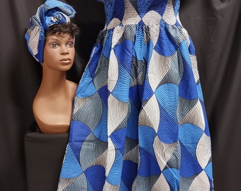 May include: A blue and white patterned off-the-shoulder dress with a ruffled neckline and a matching head wrap.