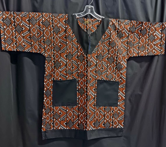 African print dashiki, brown, black and white trimmed in black. Matching Kufi sold  separately.