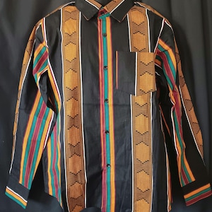 May include: A long-sleeved button-down shirt with a black background and vertical stripes in orange, green, red, and white. The stripes feature a geometric pattern.