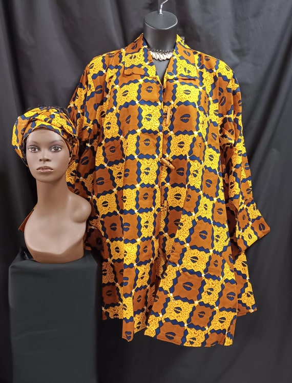 African print Jacket dress with matching head wrap. Gold,browns, navy and black cowry, swing style. Wooden Button-down front with pockets.