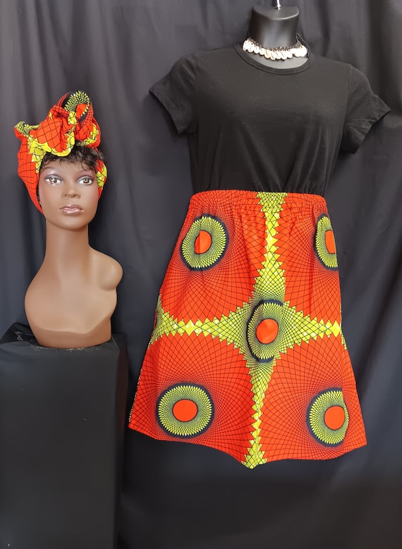 African Print Skirt, matching headwrap, elastic waist with pockets, mid-length 23" Green, reddish-orange, black. 100% Cotton. Free Shipping.