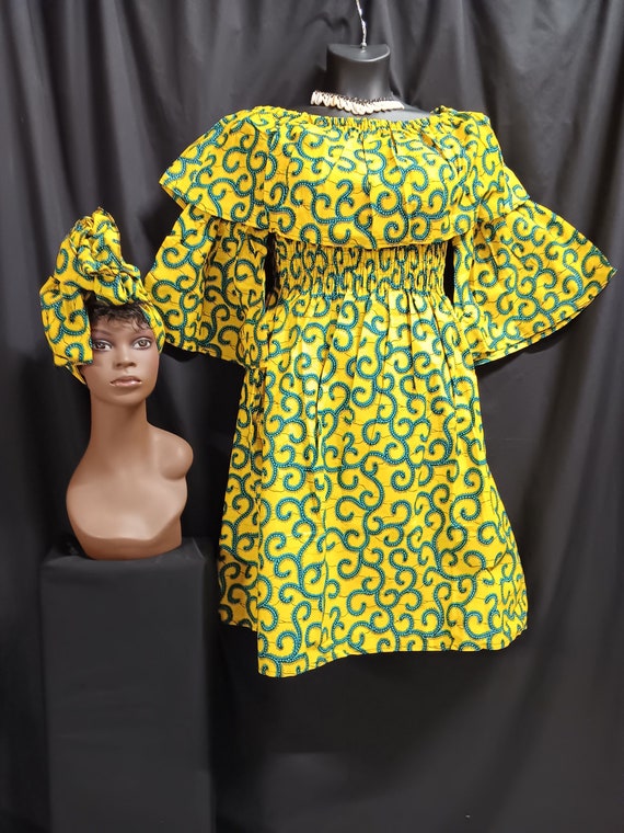 African print Dress. Over shoulder collar, elastic top to waist, pockets, elbow length full sleeves, mid length dress with matching headwrap