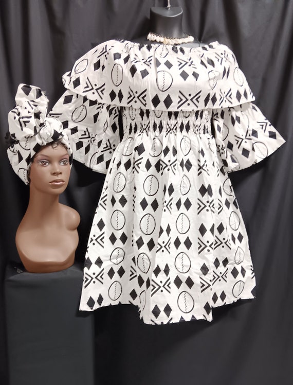African print Dress. Over shoulder collar, elastic top to waist, pockets, elbow length full sleeves, mid length dress with matching headwrap
