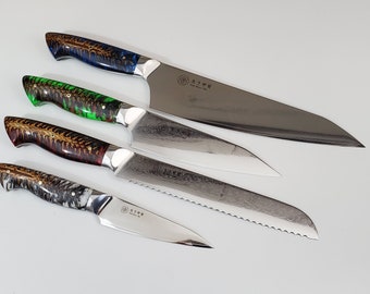 May include: Set of four kitchen knives with different blade styles and colorful, patterned handles. The knives are made of stainless steel and have a Japanese inscription on the blade.