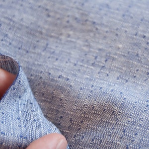 May include: Close-up of a blue and white patterned fabric with a textured weave. The fabric is soft and has a subtle sheen.