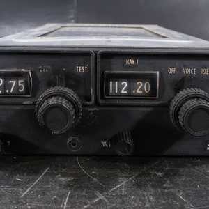 May include: Black King KX 170B aircraft radio transceiver with a digital display showing 112.20 and 153.75. The radio has knobs for tuning and a voice ident button.