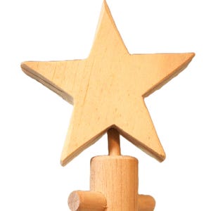 May include: A wooden star tree topper with a five-pointed star design. The star is light brown and attached to a wooden base with a cylindrical post and two horizontal dowels. The tree topper is designed to sit atop a Christmas tree.