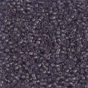 May include: A close-up view of a large quantity of small, round, opaque purple beads. The beads are all the same size and shape, and they are arranged in a random pattern.
