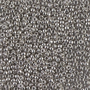May include: A close-up view of a large quantity of silver seed beads. The beads are small and round, with a shiny metallic finish.