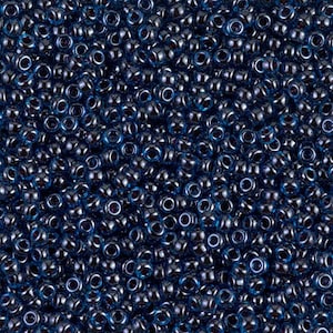 May include: A close-up image of a large quantity of dark blue seed beads. The beads are small and round, with a slightly iridescent finish.