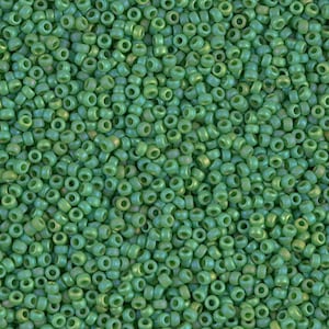 May include: A close-up image of a large quantity of small, round, green glass beads. The beads have a slightly iridescent finish.