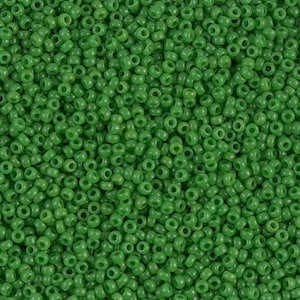 May include: A close-up view of a large quantity of small, round, green glass beads. The beads are opaque and have a smooth, shiny finish.