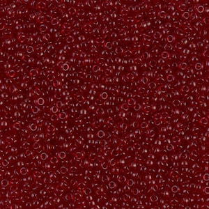 May include: A close-up image of a large quantity of small, round, red glass beads. The beads are opaque and have a slight shine.