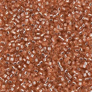 May include: Close-up of a pile of small, cylindrical beads in a copper color. The beads have a metallic silver lining inside the clear glass. These beads are ideal for jewelry making and crafting projects.
