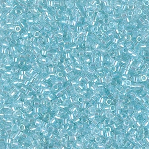 May include: A close-up view of a large quantity of small, light blue seed beads. The beads have a subtle iridescent sheen.