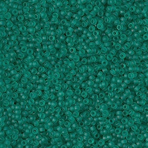 May include: A close-up image of a large quantity of small, round, teal-colored glass beads.